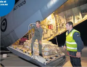  ??  ?? Air Loadmaster Sergeant Daniel Swanson (left) and aircraft maintainer Leading Aircraftma­n Liam Sole, with aid supplies delivered by a RNZAF C-130 Hercules at the Indonesian port city of Balikpapan.