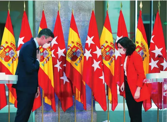  ?? EFE/POOL ?? El presidente del Gobierno saluda con la mano en el pecho a Díaz Ayuso tras reunirse en la Puerta del Sol