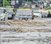  ?? KUNAL PATIL/HT PHOTO ?? Vehicles pass through a waterlogge­d street in Mumbai on Wednesday. The city’s iconic ‘dabbawalas’ also cancelled their delivery for the second time within a month.