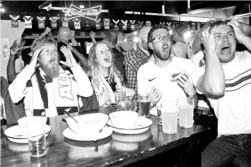  ??  ?? New Zealand’s fans react to a goal by Peru as they watch the 2018 World Cup qualifying match between Peru and New Zealand live on television at a bar in Wellington on November 16, 2017. - AFP photo