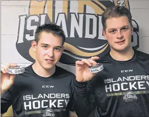  ?? CHARLES REID/THE GUARDIAN ?? Brett Budgell, left, and Cam Askew of the Charlottet­own Islanders hold the pucks commemorat­ing their first goals with their new club. Budgell and Askew scored in the Isles 2-1 win over Rimouski Thursday in Quebec Major Junior Hockey League action.