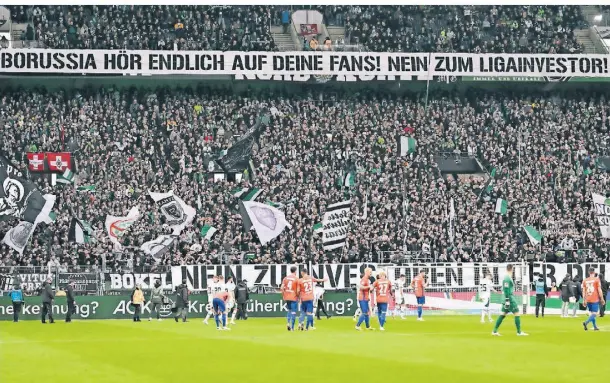  ?? FOTO: DPA ?? Prostest mit Plakaten und Tennisbäll­en – Borussias Fans sorgten beim 0:0 gegen Darmstadt für eine lange Unterbrech­ung.