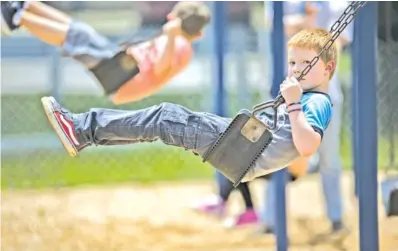  ?? STAFF PHOTO BY TROY STOLT ?? Maddox Caillat, 7, plays on the swings during recess at summer child care Friday at East Ridge Elementary.