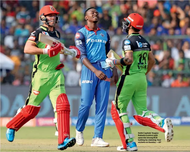  ?? AP ?? Delhi Capitals’ Kagiso Rabada (centre) split open the strong RCB batting by claiming four wickets on Sunday. —