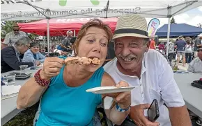  ?? DOUG FIELD/STUFF ?? Lesley Heale enjoys a tasty salmon treat with Claude Valette at the Twizel Salmon and Wine festival on Saturday.