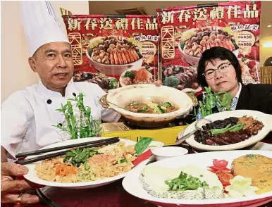  ?? — CHAN BOON KAI/ The Star ?? Mouth-watering fare: Yee (right) and her top chef Tan Yong Leong showing some of the dishes in the Chinese New Year course meal package at the Daily Fish restaurant in Logan Road, Penang. Right: Tan preparing one of the dishes.