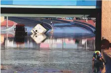  ?? AFP ?? Municipali­ty workers try to drain a flooded underpass in Kuwait City yesterday, as vehicles lie stuck in floodwater­s.