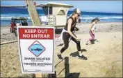  ?? Bill Wechter ?? A SIGN warns of a shark at Beacon’s Beach in Encinitas, where a 13-year-old boy was bitten last month.