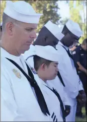  ?? PHOTO CHRIS MCDANIEL ?? Master at Arms, Second Class, Lieb, at left, and fellow sailors reflect upon the victims of the 9/11 attacks during a moment of silence.