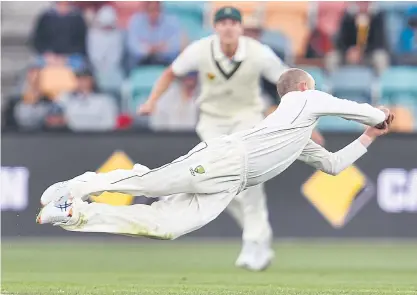  ??  ?? Australian spinner Nathan Lyon dives to take a catch to dismiss West Indies batsman Marlon Samuels.