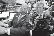  ?? [AP PHOTO] ?? Specialist Meric Greenbaum, left, and trader John Panin work Monday on the floor of the New York Stock Exchange.