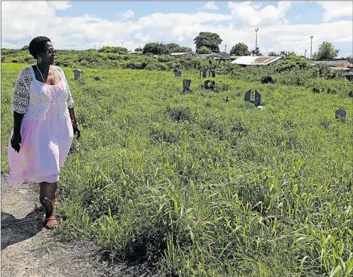  ?? Picture: ALAN EASON ?? GROWING CONCERN: Zanele Petu walks among graves that are covered by overgrown grass and bush at Lujiza Cemetery in Duncan Village. Petu is trying to find her late mother’s grave, which is hidden somewhere under the growth