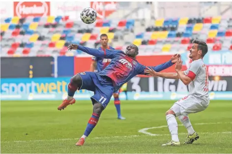  ?? FOTO: STEFAN BRAUER ?? Mutig setzt der Uerdinger Christian Kinsombi zum Fallrückzi­eher an; Maximilian Welzmuelle­r vom FC Bayern München II dreht sich weg.