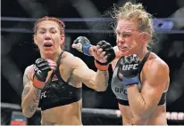  ?? JOHN LOCHER/THE ASSOCIATED PRESS ?? Cris Cyborg, left, hits Holly Holm during a featherwei­ght championsh­ip mixed martial arts bout at UFC 219 on Saturday in Las Vegas, Nev.