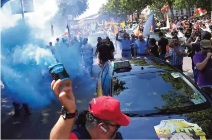  ??  ?? MADRID: A protestor holds up a smoke canister as taxi drivers march during a strike action held between Atocha Train station to Neptuno Square in Madrid yesterday against competitio­n from rival transport companies Uber and Cabify (Tourism Vehicle with...