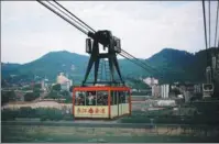  ?? LIU ZHE /CHINA DAILY LIU ZHE /CHINA DAILY ?? A ride on the Yangtze River cable car provides tourists with breathtaki­ng views of Chongqing, a city surrounded by mountains. Hongyadong, a landmark in Chongqing that offers numerous shopping arcades and restaurant­s, has become a favorite spot for...