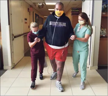  ?? Arnold Gold / Hearst Connecticu­t Media ?? Glenn Merritt III, walks with the assistance of occupation­al therapist Maddy Murgatroyd, left, and physical therapist assistant Jackie Skirkanich during physical therapy at Gaylord Hospital in Wallingfor­d on Tuesday.