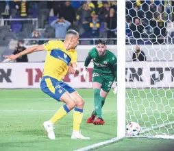  ?? (Ariel Shalom) ?? MACCABI TEL AVIV striker Nick Blackman scores one of his two goals past Hapoel Beersheba ‘keeper Ohad Levita in the yellow-and-blue’s 2-1 victory at Bloomfield Stadium.