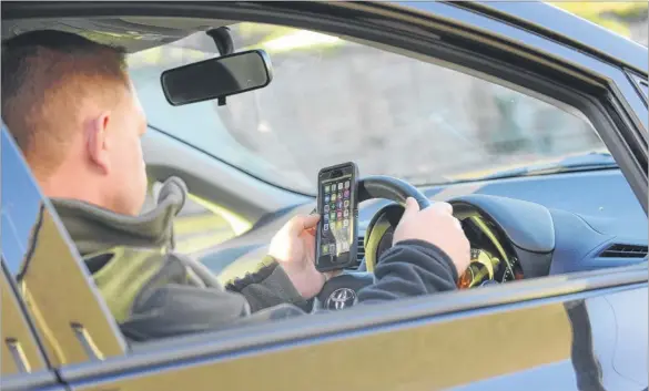  ?? Photo posed by model ?? The number of drivers penalised for using their mobile phones at the wheel has dropped dramatical­ly