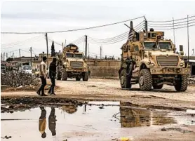  ?? DELIL SOULEIMAN/GETTY-AFP ?? A U.S. military convoy patrols Wednesday in the outskirts of the Kurdish-controlled northern Syrian city of Qamishli. U.S. forces confronted Syrian troops at a checkpoint.