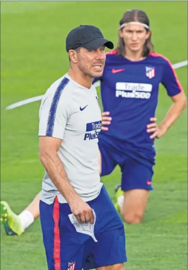  ??  ?? ENTRENO. Filipe Luis, al fondo, en la sesión de entrenamie­nto del Atlético, con Simeone en primer plano.