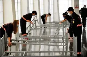  ?? AP ?? Workers set up hospital beds for COVID-19 patients at a sports hall in Zagreb, Croatia, on Oct. 26.