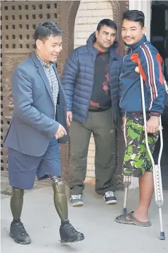  ?? — AFP photo ?? Magar (left), who lost both his legs in Afghanista­n and hoped to climb Everest, walks in Kathmandu.