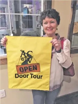  ?? BY JOHN MCCASLIN ?? Rappahanno­ck artist and ‘Second Saturday’ organizer Patti Brennan models the Open Door Tour banner.