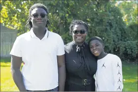  ?? PAUL SANCYA — THE ASSOCIATED PRESS ?? Joelle Wright-Terry poses with her sons Joshua and Micah in Clinton Township. “My dad was my best friend,” Joshua says about Marshall Terry III, who died in April from symptoms of coronaviru­s. “My goal is to make him proud while he watches from heaven.”