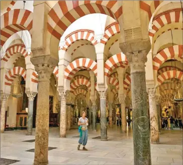  ?? AFP ?? A lone tourist walks inside Cordoba, Spain’s Mezquita – an eigth-century Moorish mosque turned cathedral and UNESCO World Heritage site – that used to draw thousands of visitors per week.