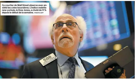  ?? PHOTO AFP ?? Ce courtier de Wall Street observe avec anxiété les cotes boursières. L’indice vedette new-yorkais, le Dow Jones, a chuté de 11 % depuis le début de la semaine.