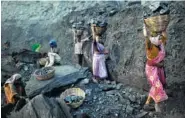  ?? ASSOCIATED PRESS FILE PHOTO ?? People carry baskets of coal scavenged illegally at an opencast mine in the village of Bokapahari in the eastern Indian state of Jharkhand where a community of coal scavengers live and work.