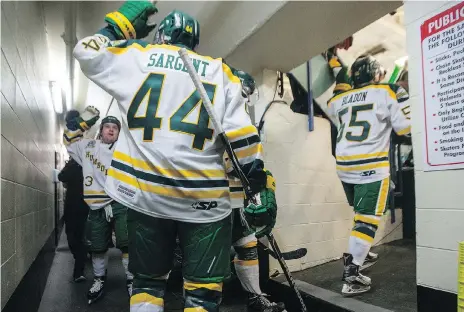  ??  ?? Broncos forward Derek Patter, left, high-fives defenceman Kyle Sargent as he and his teammates head onto the ice.