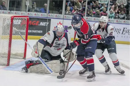  ?? ERIC YOUNG/SAGINAW SPIRIT ?? Spitfires goalie Kari Piiroinen and defenceman Thomas Stevenson battle Saginaw’s Cole Perfetti during Saturday game.