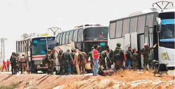  ?? AP ?? Russian soldiers and Syrian government forces overseeing the evacuation of rebel fighters from the Army of Islam and their families from Dumayr, northeast of Damascus, yesterday.