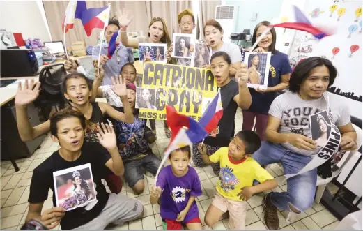  ??  ?? CATRIONA’S WARDS – Out-ofschool children belonging to Young Focus, Miss Universe Catriona Gray’s charity NGO in Tondo, Manila, celebrate her victory. Gray is a volunteer for the group that provides free education for kids who have no access to primary schooling. (Ali Vicoy)