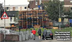  ??  ?? The controvers­ial bonfire in the New Lodge area; (left)
sinister graffiti