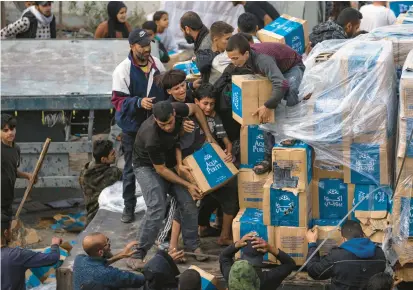  ?? FATIMA SHBAIR/AP ?? Desperate Palestinia­ns loot a humanitari­an aid truck as it crosses into the Gaza Strip in Rafah on Sunday.