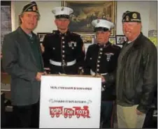  ??  ?? Springfiel­d American Legion Post Commander Rocco Polidoro, two members of the Folsom US Marine Reserve Center and Legion Vice Commander Bill Smeck prepare the legion’s collection site for the U.S.M.C. Reserves Toys for Tots drive.