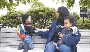  ?? GILLIAN FLACCUS/AP ?? Callie Coppage, of Portland, Ore., sits with her sons — Anthony, 3, and Royal, 11 months — on May 13 near the Willamette River. Coppage received $7,000 from a multimilli­onaire after tweeting a photo of herself and her infant son.