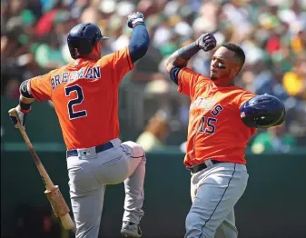  ?? Associated Press ?? ■ Houston Astros' Martin Maldonado, right, celebrates with Alex Bregman (2) after hitting a home run off Oakland Athletics' Emilio Pagan in the seventh inning of a baseball game Sunday in Oakland, Calif.