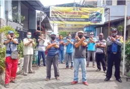  ?? JUNEKA SUBAIHUL MUFID,/JAWA POS ?? GOTONG ROYONG: Pengurus kampung berjaga di Jalan Rungkut Lor VII, Sabtu (20/6). Mereka memastikan warga mematuhi protokol kesehatan.