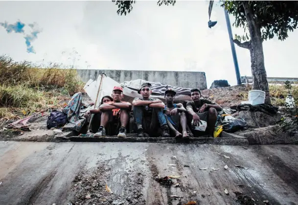  ??  ?? Une bande de jeunes chercheurs d’or vivant au bord de la rivière. Juste derrière eux, la grande voie express de la capitale.