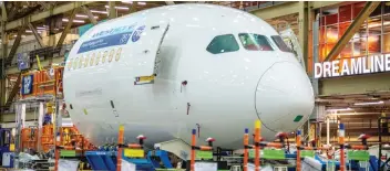  ??  ?? A 787 Dreamliner, which has a range in excess of 14,000 kms., moves along a Boeing assembly line.