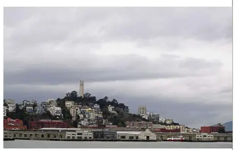  ?? — AP ?? Good and bad: A weather front bringing rain moves in behind Coit Tower on Telegraph Hill in San Francisco. Light rain falling in some areas of northern California could aid crews fighting a deadly wildfire while raising the risk of flash floods and complicati­ng efforts to recover the remains of those killed.