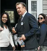  ?? STEVE HELBER/AP ?? Alec Baldwin and Democratic candidate Amanda Pohl, right, knock on doors Tuesday in Virginia.