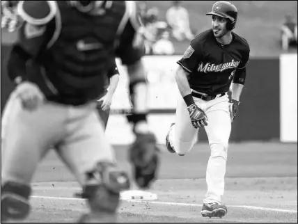  ?? AP PHOTO/MATT YORK ?? Milwaukee Brewers’ Ryan Braun scores on against the Colorado Rockies in Phoenix. a throwing error during the first inning of a spring training baseball game