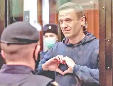  ?? — AFP photo ?? Navalny gesturing a heart shape from inside a glass cell during a court hearing in Moscow.