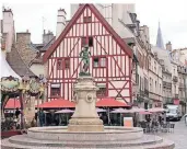  ?? FOTO: JULIA SIEGERS ?? Am Place François Rude erinnert der alte Brunnen mit dem Winzer beim Keltern an die Zeit, als die Trauben noch mit den Füßen gepresst wurden.