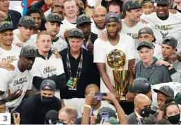  ?? PHOTOS AFP ?? 1. Giannis Antetokoun­mpo avec le trophée du meilleur joueur des séries éliminatoi­res. 2. Devin Booker, des Suns de Pheonix, est frustré par Jrue Holiday, des Bucks. 3. La photo d’équipe des Bucks de Milwaukee avec le trophée Larry O’Brien. 3